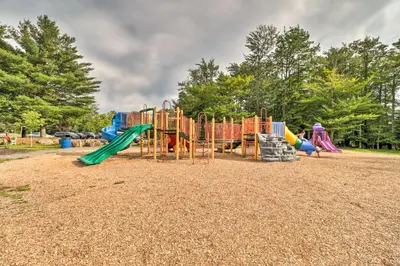 a playground with a slide and a play structure at Pocono Vacation Rental with Game Room! in Tobyhanna