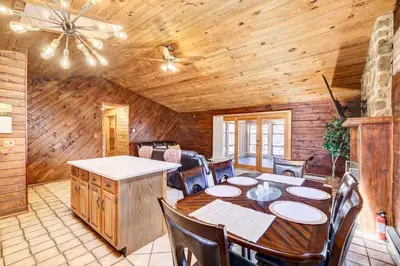 a dining room with a table and chairs in a cabin at Pocono Vacation Rental with Game Room! in Tobyhanna