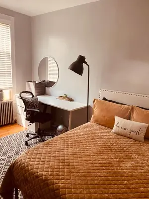 a bedroom with a bed with a desk and a lamp at Private Rooms in TownHouse w Shared Baths Qn Bed 1-3ppl in Unionport