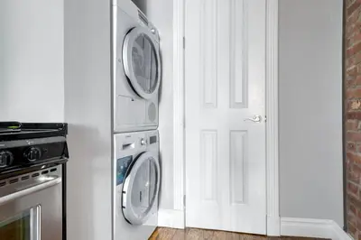 a kitchen with a washer and dryer next to a door at East Village 1br w wd nr cafes NYC-1115 in New York