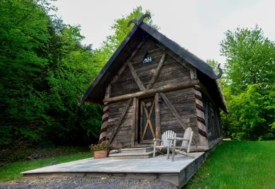 a log cabin with two chairs on a deck at Vikings Villages Resort in Guilford