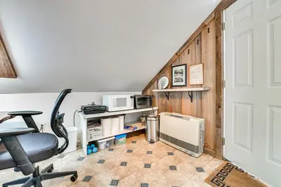 a room with a staircase with a desk and a chair at Cozy Catskills Vacation Rental with Deck! in Fleischmanns