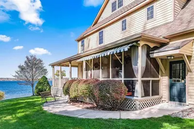 a house with a front porch and a lawn at Artemis Lakehouse - Hot Tub, Lakefront & Racetrack in Saratoga Springs