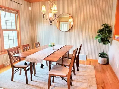 a dining room table with chairs and a mirror at Artemis Lakehouse - Hot Tub, Lakefront & Racetrack in Saratoga Springs