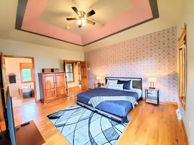 a bedroom with a bed and a ceiling fan at Artemis Lakehouse - Hot Tub, Lakefront & Racetrack in Saratoga Springs