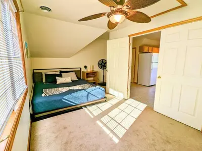 a bedroom with a bed and a ceiling fan at Artemis Lakehouse - Hot Tub, Lakefront & Racetrack in Saratoga Springs