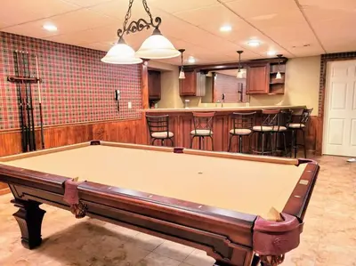 a pool table in a room with a bar at Artemis Lakehouse - Hot Tub, Lakefront & Racetrack in Saratoga Springs