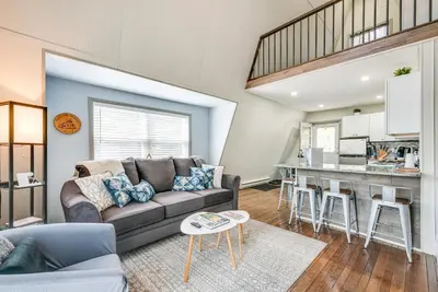 a living room with a couch and a kitchen at Dock and Sunroom Waterfront Home Near Kalahari! in Pocono Summit