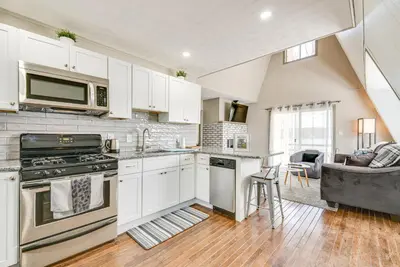 a kitchen with white cabinets and a stove top oven at Dock and Sunroom Waterfront Home Near Kalahari! in Pocono Summit