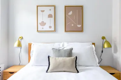 a bedroom with a white bed with two lamps at UWS 1BR w Gym Doorman nr Riverside Park NYC-511 in New York