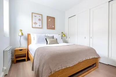 a white bedroom with a large bed with white walls at UWS 1BR w Gym Doorman nr Riverside Park NYC-511 in New York