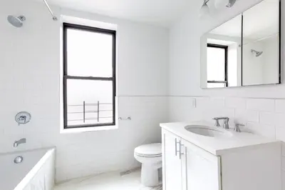 a white bathroom with a sink and a mirror at UWS 1BR w Gym Doorman nr Riverside Park NYC-511 in New York