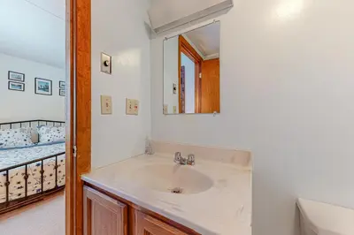 a bathroom with a sink and a mirror and a bed at Mountain Village #5H in Dover