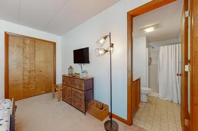 a bedroom with a bed and a television and a bathroom at Mountain Village 5H Unit B in Dover