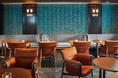 a restaurant with tables and chairs in a room with green wallpaper at The Prince Kitano New York in New York