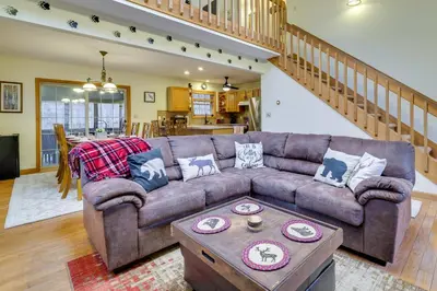 a living room with a brown couch and a table at Hot Tub, Game Room! Poconos Home 22 Mi to Slopes in Gouldsboro