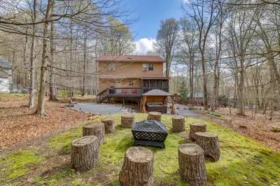 a house with a bunch of logs in front of it at Hot Tub, Game Room! Poconos Home 22 Mi to Slopes in Gouldsboro