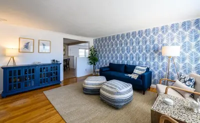 a living room with a blue couch and a table at Cozy Connecticut Beach House in East Haven