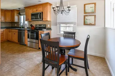 a kitchen with a wooden table and chairs in it at Cozy Connecticut Beach House in East Haven