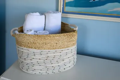 a basket filled with towels sitting on a table at Cozy Connecticut Beach House in East Haven