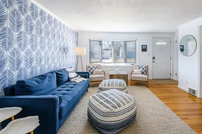 a living room with a blue couch and chairs at Cozy Connecticut Beach House in East Haven