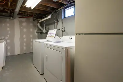 a laundry room with a washer and a refrigerator at Cozy Connecticut Beach House in East Haven