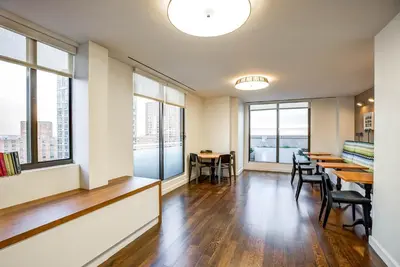 a dining room with tables and chairs and windows at UES 2br w wd gym doorman nr Cooper Hewitt NYC-1117 in New York