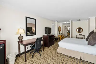 a hotel room with a bed and a desk at Executive Inn - Fort Lee in Fort Lee