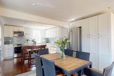 a kitchen with a table with a vase of flowers on it at White Oaks in Branford