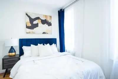 a bedroom with a bed with a blue headboard at 49-4A Prime Midtown newly 2BR WD in New York