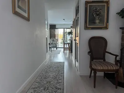 a hallway with a chair and a rug at One bedroom with modern kitchen, balcony with water view in Greenwich