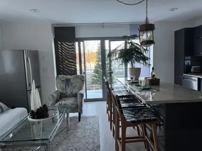a kitchen with a bar with a glass counter top at One bedroom with modern kitchen, balcony with water view in Greenwich