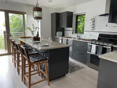 a kitchen with a large island with bar stools at One bedroom with modern kitchen, balcony with water view in Greenwich