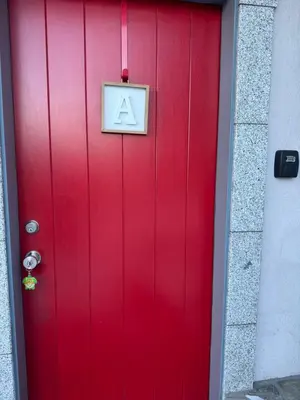 a red door with a sign on it at One bedroom with modern kitchen, balcony with water view in Greenwich