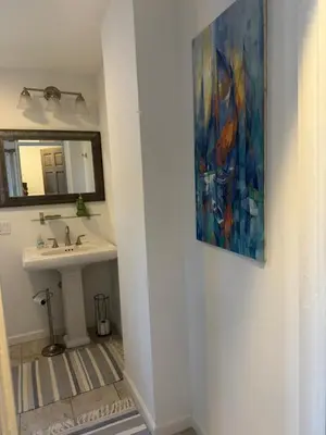 a bathroom with a sink and a painting on the wall at One bedroom with modern kitchen, balcony with water view in Greenwich