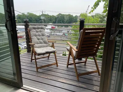two chairs on a deck with a view of the water at One bedroom with modern kitchen, balcony with water view in Greenwich
