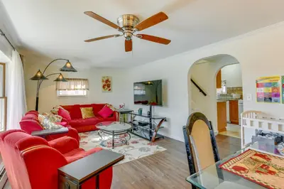 a living room with a red couch and a table at Milford Family Home with Koi Pond and Porch! in West Milford