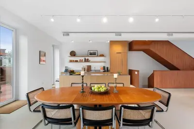 a kitchen and dining room with a wooden table and chairs at 4BR Greenpoint Duplex Noorman by RoveTravel in Brooklyn
