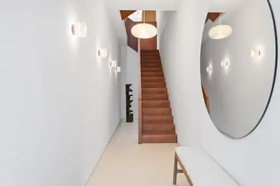a hallway with a mirror and a staircase at 4BR Greenpoint Duplex Noorman by RoveTravel in Brooklyn