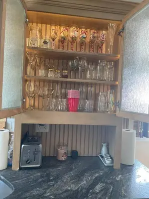 a shelf with many glasses on it in a kitchen at A little place in the Sun in Milford