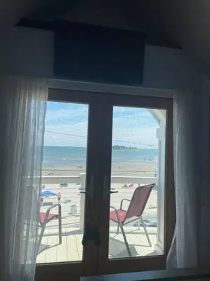 a room with a window with a view of the beach at A little place in the Sun in Milford