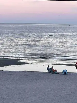 two people sitting on the beach near the water at A little place in the Sun in Milford