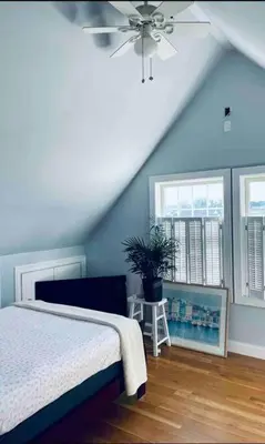 a bedroom with a bed and a ceiling fan at A little place in the Sun in Milford