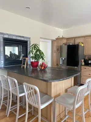 a kitchen with a island with chairs and a counter top at A little place in the Sun in Milford