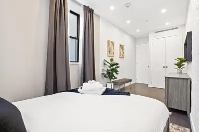 a bedroom with a large white bed and a window at SWJ 1st - Near Most Attractions Walk to Train Times Sq near in New York
