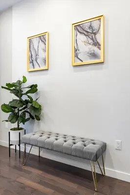 a bench in a room with two pictures on the wall at SWJ 1st - Near Most Attractions Walk to Train Times Sq near in New York