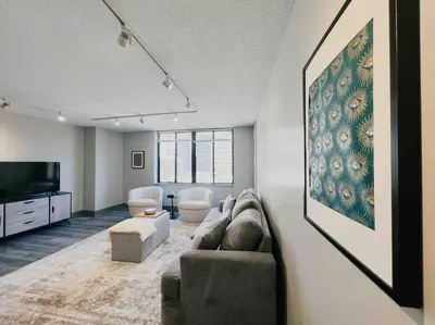 a living room with a couch and a flat screen tv at Downtown Hartford Condo - XL Center in Hartford