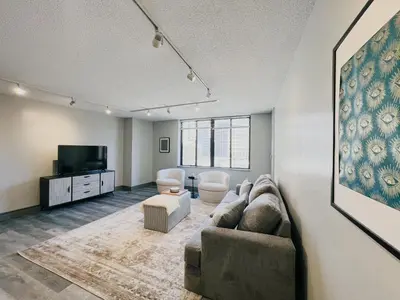 a living room with a couch and a flat screen tv at Downtown Hartford Condo - XL Center in Hartford