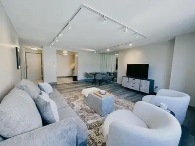 a living room with a couch and chairs and a tv at Downtown Hartford Condo - XL Center in Hartford