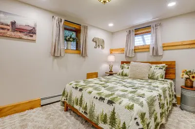 a bedroom with a bed with a green comforter at Honey Paws Inn Wilmington Home 6 Mi to Mount Snow in Wilmington